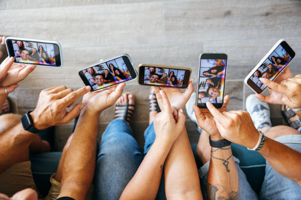 freunde auf ihren handys schauen sich ihr selfie an - photographing smart phone friendship photo messaging stock-fotos und bilder