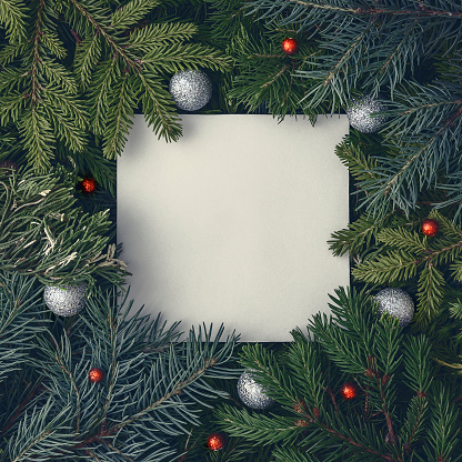 Diseño navideño de ramas de abeto y enebro con una tarjeta de papel. Antecedentes conceptuales de Año Nuevo. photo