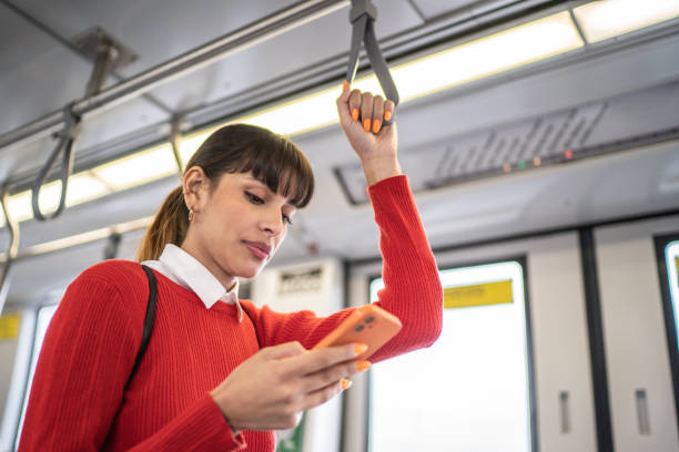 istock Young woman using the mobile phone in the subway train 1423124494