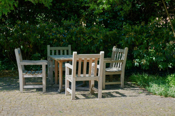 Cup of coffee or tea on wooden table next to blooming tree in a garden