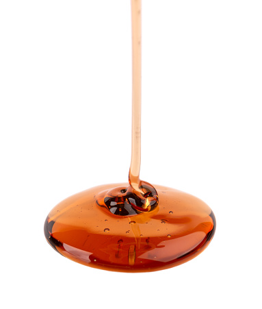 Caramel syrup drizzle isolated on white background. Splashes of sweet caramel sauce