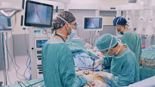 Team of doctors and nurses doing laparoscopic surgery together stock photo