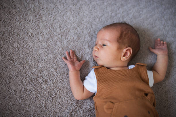 istock Young baby lying on bed and discovering the world 1423137602