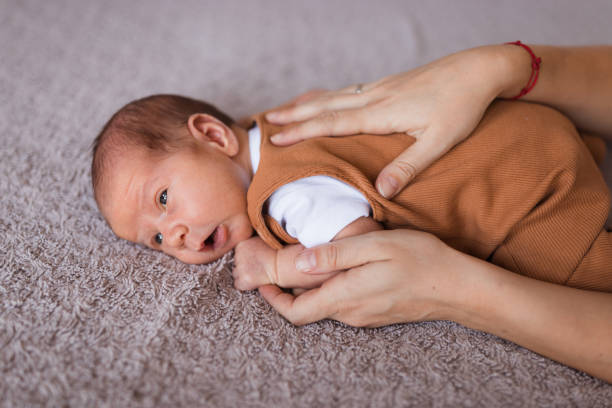 madre che tocca la schiena del neonato durante l'episodio di crampi - cramping foto e immagini stock