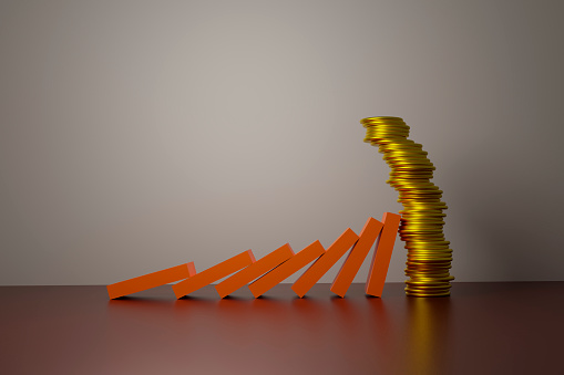Orange pieces hitting a stack of coins as in dominoes effect