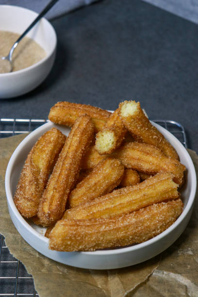 istock churros with sugar in white bowl on grey table, top view 1423140504