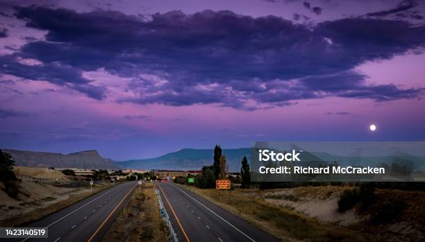 Beautiful Sunset Picture Of Interstate I70 Grand Junction Colorado With Mount Garfield And Grand Mesa In The Background And A Full Moon Rising Stock Photo - Download Image Now