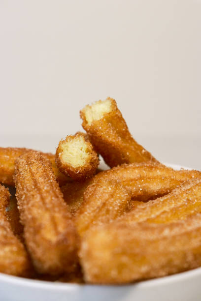 istock close up of churros with sugar, white background with copy space 1423140533