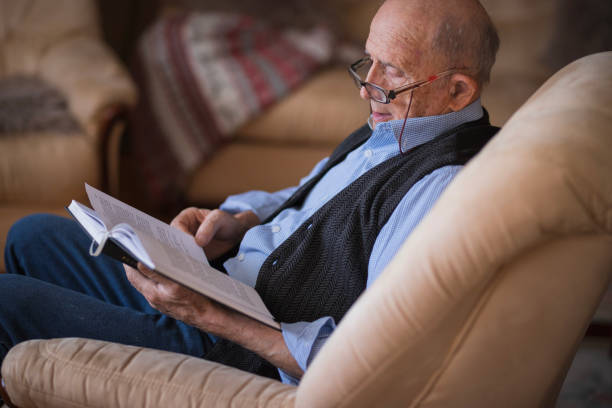 istock Old man resting at home and reading a book 1423140541