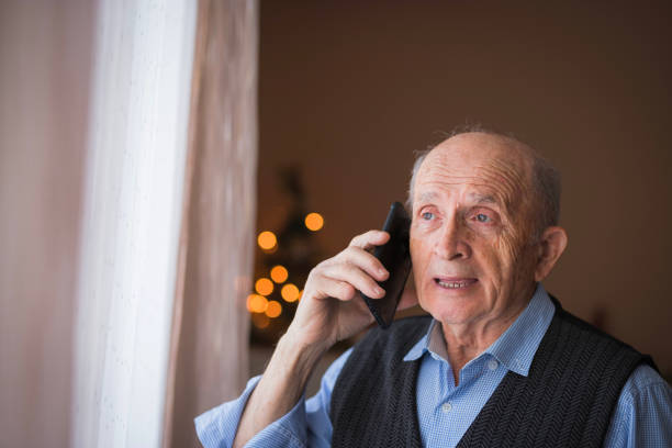 istock Senior man standing by the window and arguing on phone 1423140883