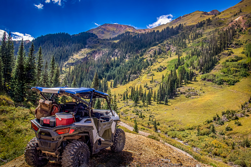 UTV side by side RZR with a Beautiful Mountain range in the background along the Poughkeepsi gulch trail near Silverton and Ouray Colorado in the San Juan Mountains, Rocky Mountains Colorado.