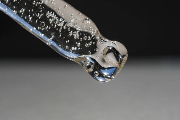 istock Transparent pipette with cosmetic liquid on a dark gray background. Side view, close-up. 1423142641