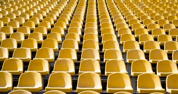 seats of tribune on sport stadium. empty outdoor arena. concept of fans. chairs for audience. cultural environment concept. color and symmetry. empty seats. modern stadium. yellow tribunes.