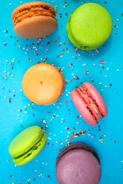 istock Colorful macaroons on a blue background. Flat lay, Vertical image. 1423147687
