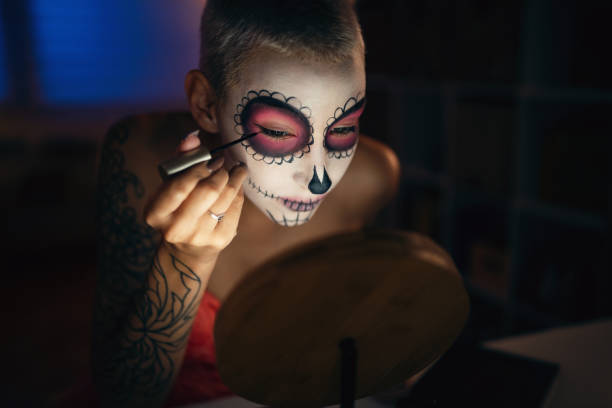 istock Young woman doing make-up for Day of the Dead celebration 1423149502