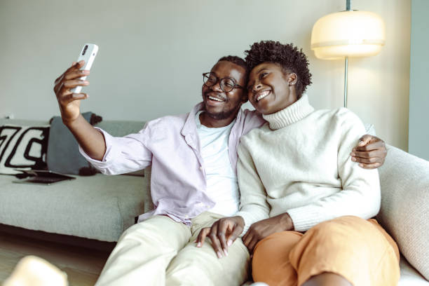 istock Happy African-American couple using smart phone and taking selfie 1423149575