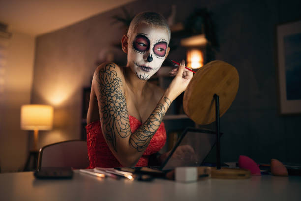 istock Young woman doing make-up for Day of the Dead celebration 1423149579