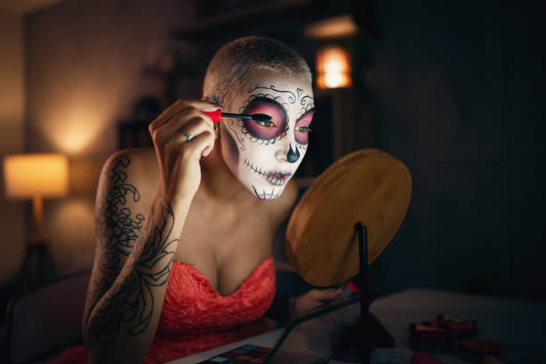 istock Young woman doing make-up for Day of the Dead celebration 1423149949