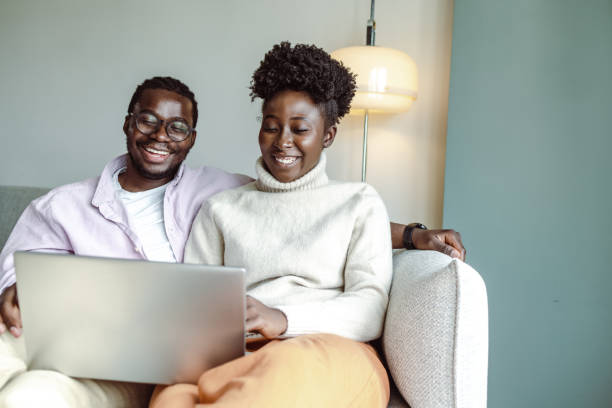 istock Young African-American couple using laptop at home 1423150104