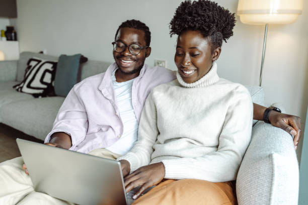 istock Young African-American couple using laptop at home 1423150237