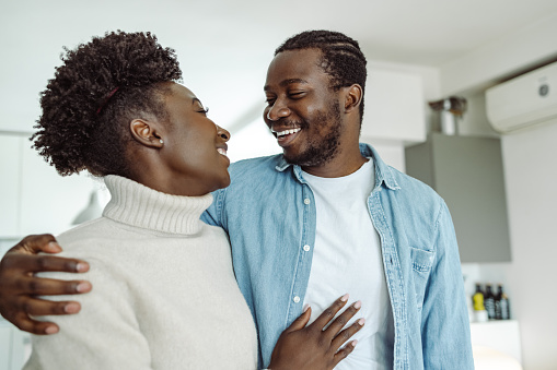 Happy African-American couple embracing at home