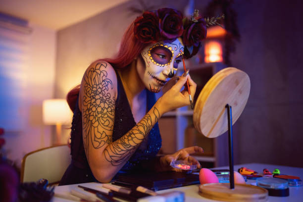 istock Young woman doing make-up for Day of the Dead celebration 1423155395