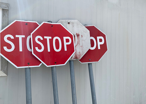 Closeup of worn, generic street stop signs in a junkyard.
