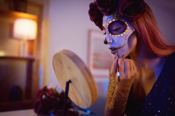 istock Young woman doing make-up for Day of the Dead celebration 1423155652