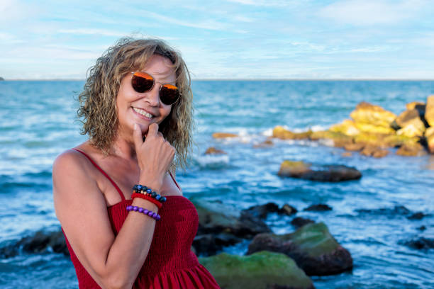 woman over 50 in red on the beach