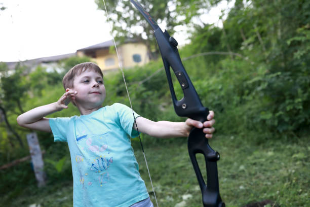 istock Boy shooting bow in park 1423158001