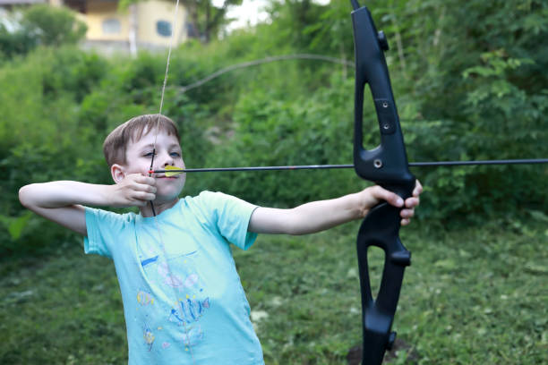 istock Child shooting bow in park 1423158014