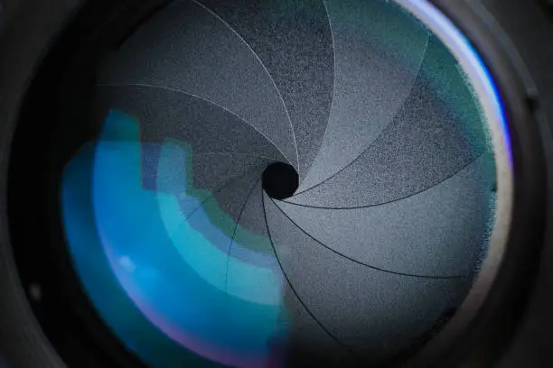 Close up Aperture camera lens with blue coating .