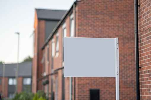 white empty space House for Sale in United Kingdom. A real estate agent For Sale sign on a residential street in UK.For Sale Sign.