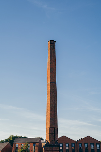 Two chimneys of a thermal power station behind trees