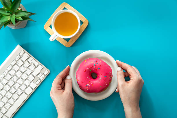 istock Donut, tea and keyboard on a blue background, flat lay. 1423161837
