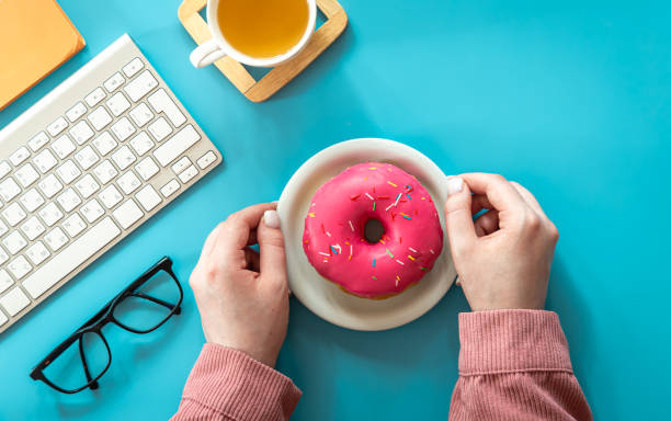 istock Donut, tea and keyboard on a blue background, flat lay. 1423161841