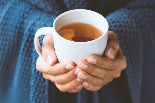 Woman holding a cup of tea.