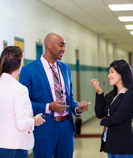 istock Multiracial group of teachers meet in school hallway 1423165233