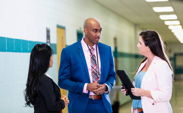 istock Multiracial group of teachers meet in school hallway 1423165242