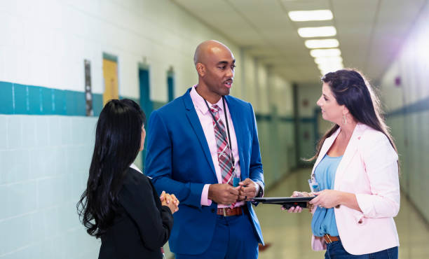 istock Multiracial group of teachers meet in school hallway 1423165264