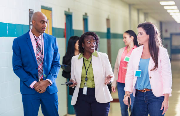 istock Multiracial group of teachers walking in school hallway 1423165394