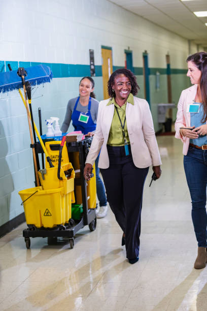 istock Teachers and janitor walking thru school corridor 1423165627