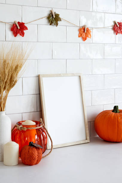 istock Mockup picture frame with autumn decorations, pumpkins on white table. Fall, Thanksgiving, Halloween concept. 1423167757