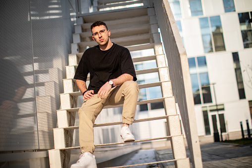 young man siting on stairs, posing