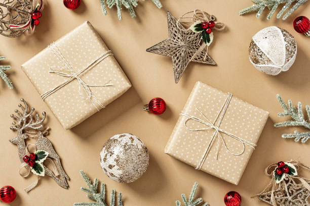 istock Craft Christmas gift boxes with fir branches, vintage decorations on beige background. Christmas holiday celebration, winter, New Year concept. Flat lay, top view. 1423168581