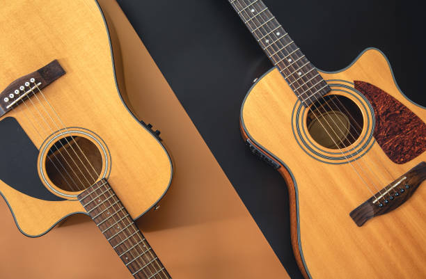 istock Two acoustic guitars on a colored background, flat lay. 1423168795