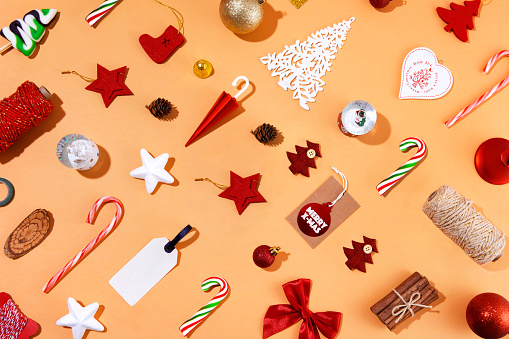 Christmas ornaments, gifts and candy canes on orange background