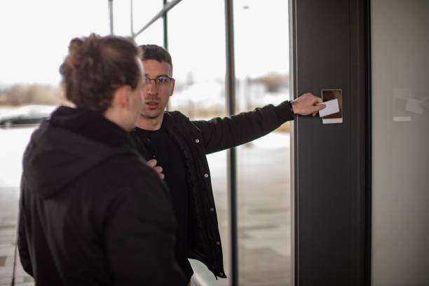 istock Card reading at company building, friends coworkers arrive at work 1423169113