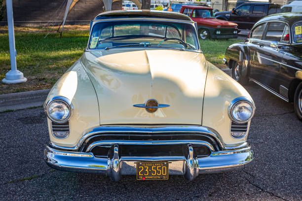 Vintage Elegance: Detailed View of a Classic Car's Chrome Headlight and Iconic Grille - Preserving Automotive History