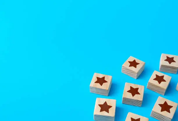 Photo of Scattered star blocks on a blue background. Feedback. Inspection, review. Benefits, positive things. New features. Ratings and reviews. Parties and celebrate events.
